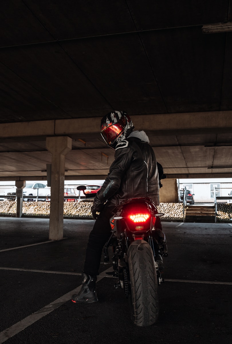 Motorcyclist sitting on bike, looking back.